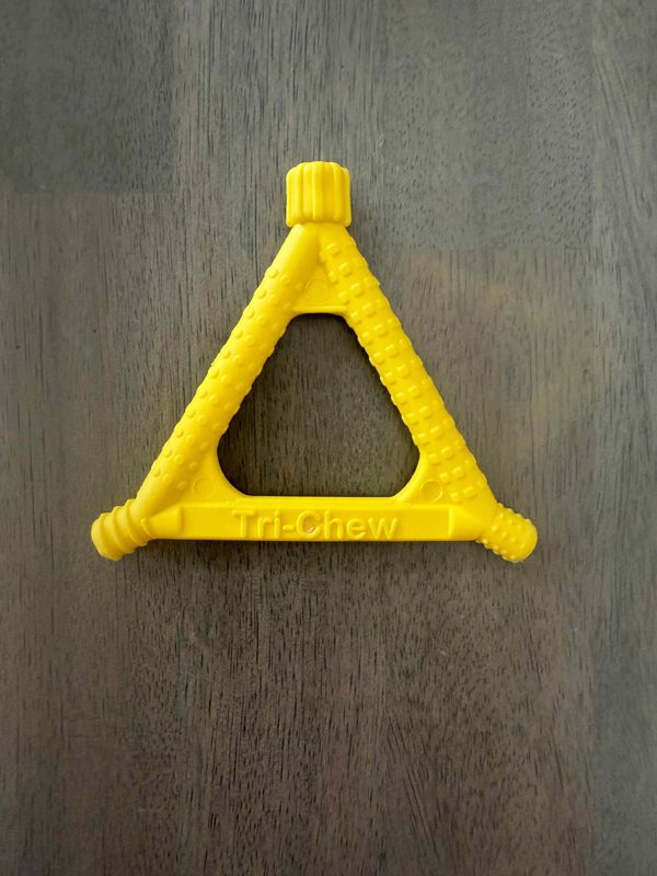 A yellow triangle-shaped chew tool with textured sides