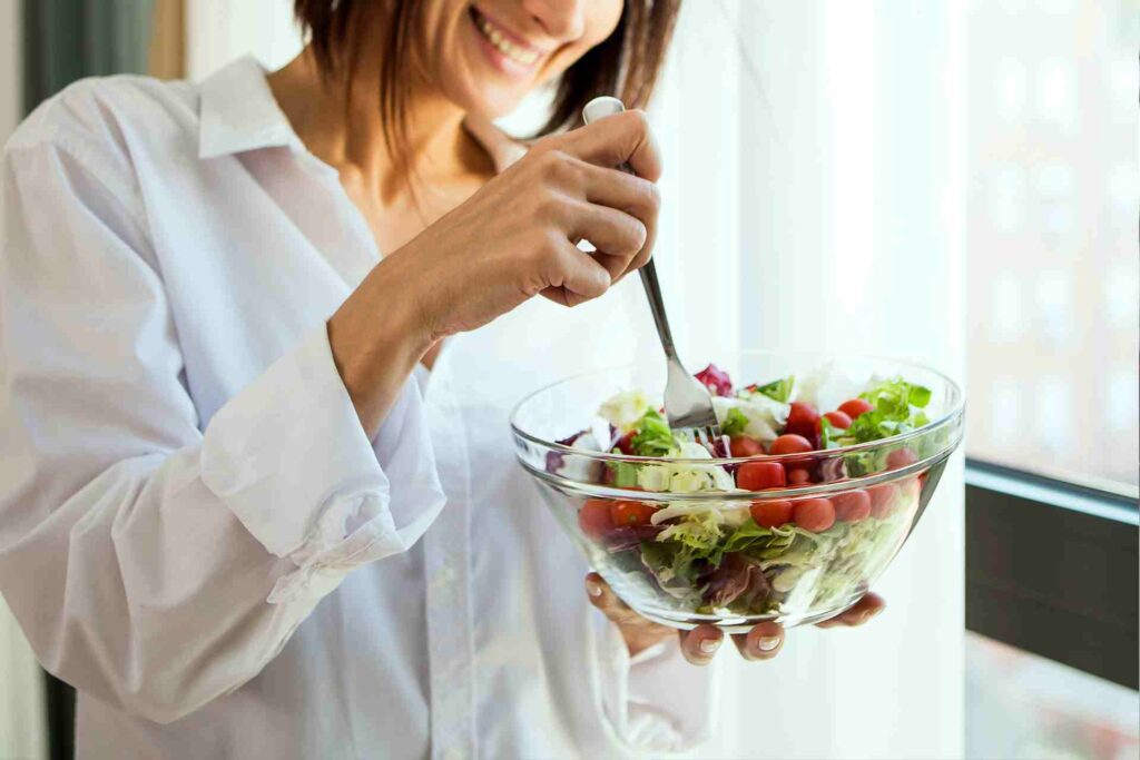 Young woman eating salad.