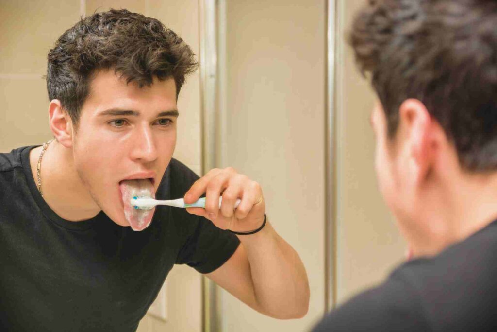 Man brushing teeth and tongue