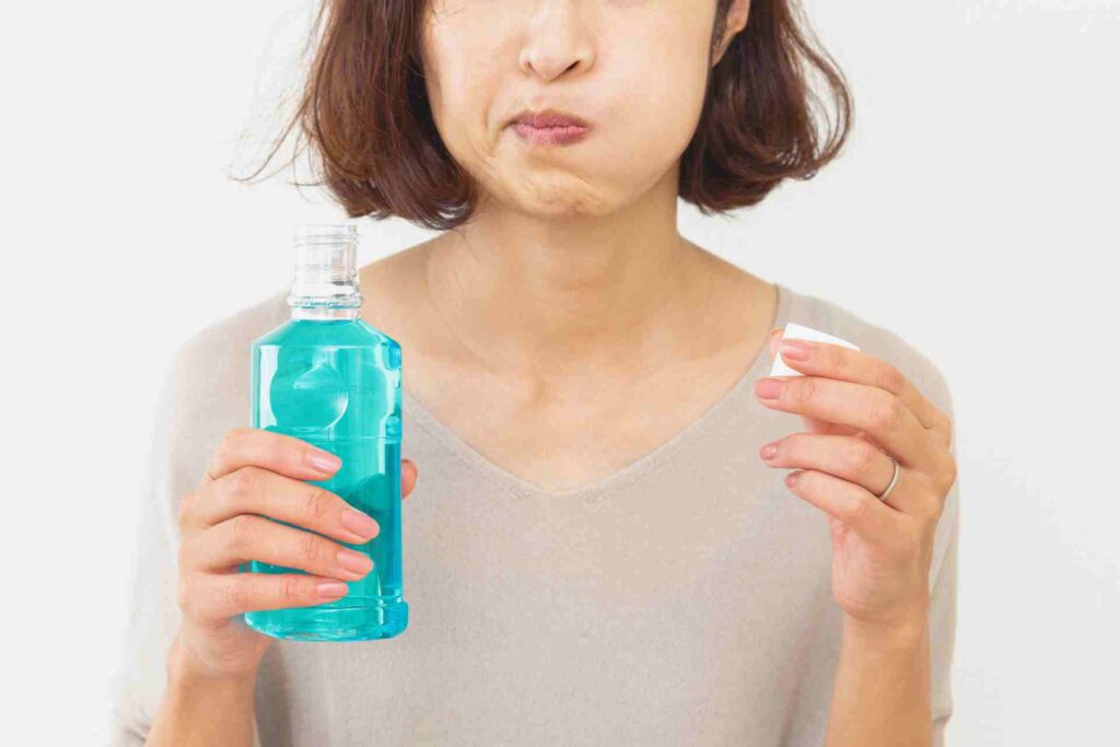 Woman using mouthwash.
