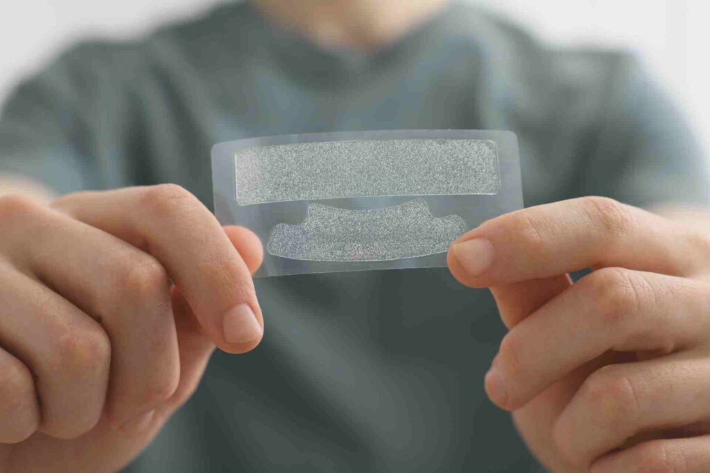 Young Man with Whitening Strips.