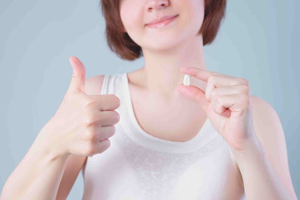 Wisdom teeth extraction, happy woman with tooth in hand.