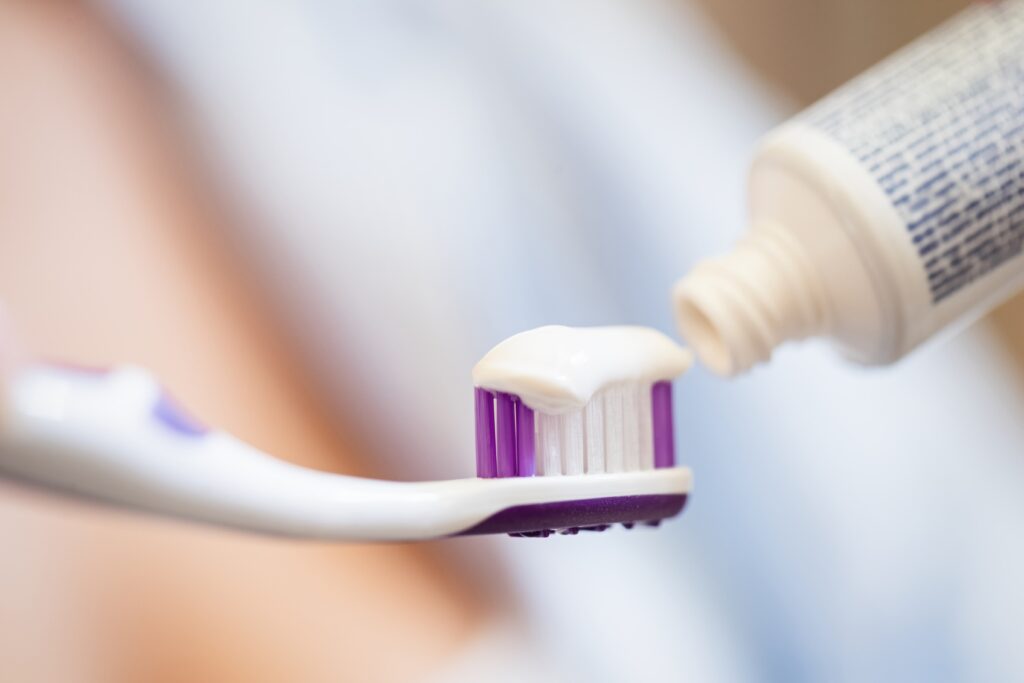 Close-up of unrecognizable person applying toothpaste.