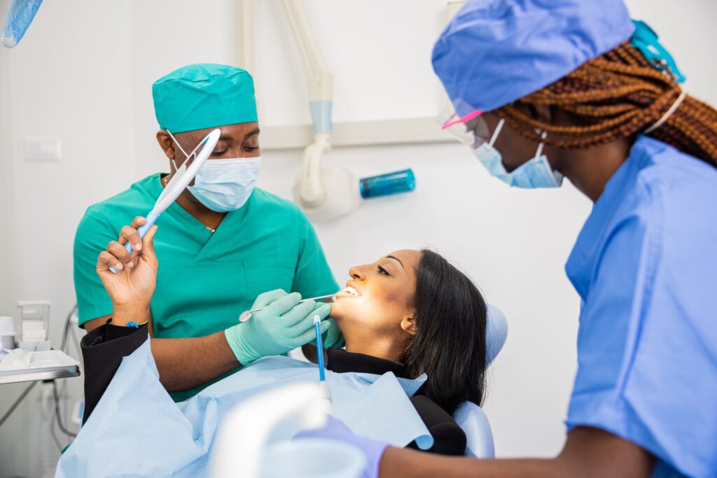 A patient looks at her teeth through the mirror