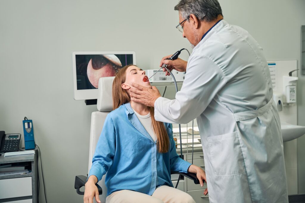 Doctor performs an oral exam procedure on a seated patient.