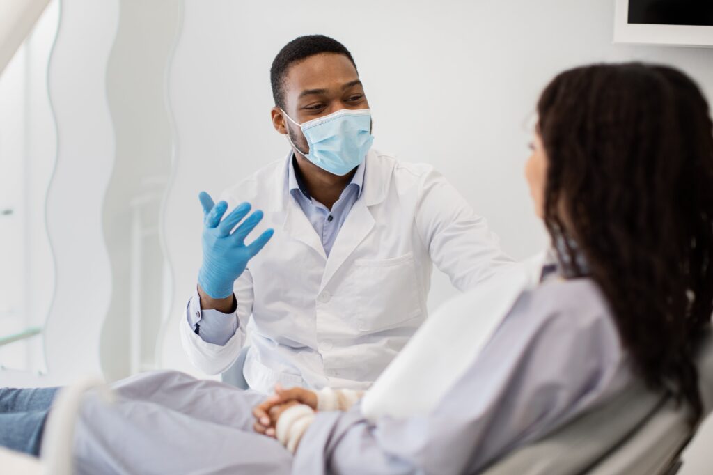 Dentist with Consulting Female Patient In Clinic